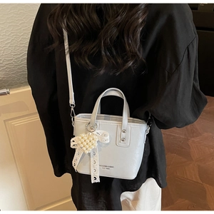 Detail einer schicken Beuteltasche mit Spitzenbogen und Perlen-Herz-Anhänger