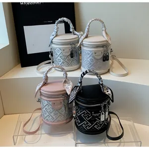 Détails de sacs seaux cylindriques colorés avec motifs et poignées en foulard de soie