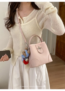 Pink lychee grain leather bucket bag with silver T-clasp and cute teddy bear charm