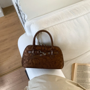 Detailed view of brown vintage satchel with metal buckle and weathered leather texture