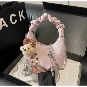 Rosa Hobo-Handtasche im Detail mit Falten-Griff und süßem Plüschbär-Anhänger mit Schleife