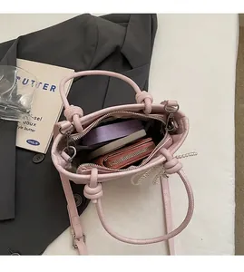 Sac seau en cuir rose avec intérieur spacieux et détail de chaîne en perles élégante