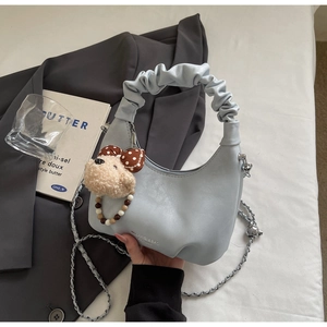 Detail der hellblauen Falten-Tasche mit Plüschwelpen-Anhänger und silberner Kette