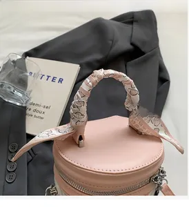 Détail du sac seau rose avec poignée en soie et fermeture éclair argentée