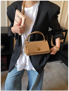 Detail of khaki crossbody bag with gold twist lock on a minimalist blazer outfit