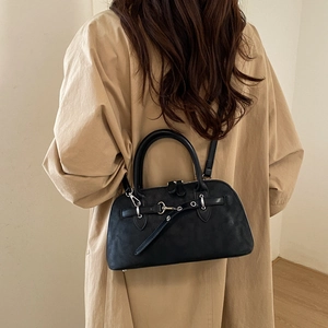 Detail of matte black domed crossbody bag with silver hardware and double handles