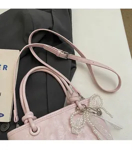 Sac minimaliste en cuir texturé rose clair avec un charmant nœud en dentelle et perles