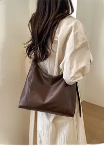 Detailed back view of a large dark brown matte leather shoulder bag with wide strap