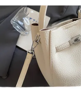 Dettaglio della borsa a secchiello in pelle martellata bianco sporco con chiusura a scatto