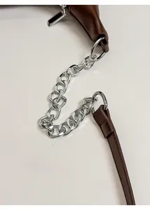 Detail of high-gloss silver metal chain hardware on a premium brown leather tote bag