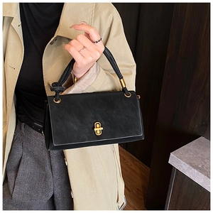 Detail of black leather handbag with gold metal twist lock and decorative knotted handle