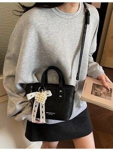 Schicke schwarze Lederbeuteltasche mit Perlen-Herzanhänger und verstellbarem Schultergurt