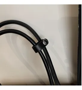 Détail de la bandoulière en cuir noir avec boucle métallique argentée polie sur le sac