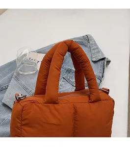 Detailed view of caramel quilted nylon tote bag with soft padded handles and metal zipper
