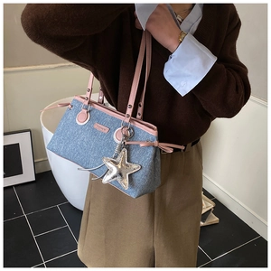 Détail du sac bowling en jean avec garniture en cuir rose et écusson fashion