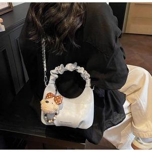 Detail der hellgrauen Hobo-Tasche mit gerafftem Griff und süßem Bären-Anhänger