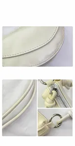 Close-up of cream leather saddle bag showing silver zipper and precise stitching details