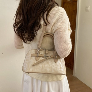 Detail of off-white retro pillow bag showing marble texture and silver buckle