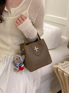 Brown lychee leather bucket bag with silver twist lock and cute bear charm pendant