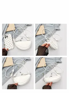 Detail view of white moon saddle bag featuring minimalist knotted rope shoulder strap design