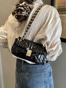 Chic black quilted crossbody bag with gold chain strap and elegant metallic turn-lock