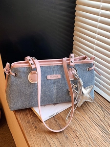 Sac bowling chic en denim bleu avec garniture en cuir rose et breloques en métal