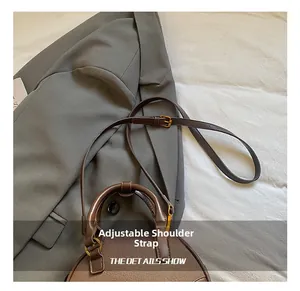 Detail of adjustable leather strap with gold buckle on a brown vintage bowling bag
