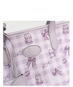 Gros plan du sac cabas lilas montrant le cuir grainé et les motifs de chats