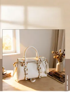 Close-up of creamy white Boston bag with pleated leather texture and gold hardware
