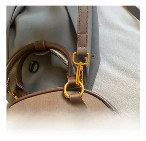 Close-up of golden hardware and pebble grain leather strap on a brown bowling bag