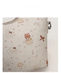 Close-up of litchi textured leather featuring pink cartoon cats and cupcake prints