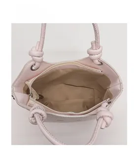 Top-down view of pink leather handbag interior showing beige lining and spacious storage