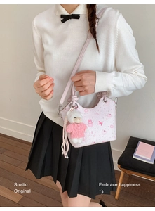 Detail view of pink PU bucket bag with cute bear patterns and plush bear charm accessory