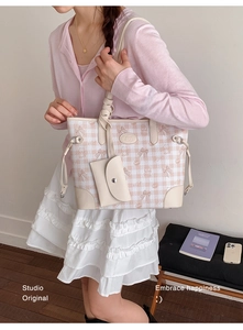 Detail of pink plaid tote bag with bear patterns and matching mini pouch on shoulder