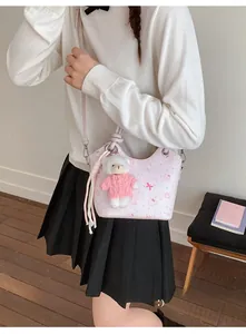 Detail of light pink floral crossbody bag with a cute teddy bear plush charm