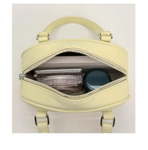 Top view of cream yellow baguette bag interior showing capacity for cosmetics and phone