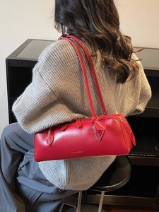 Sac baguette femme en cuir rouge minimaliste porté à l'épaule sur un mannequin élégant