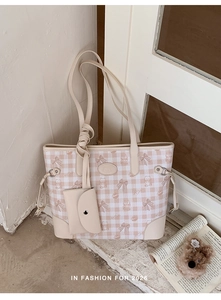 Close-up of beige plaid tote bag with cute cartoon prints and a matching mini pouch