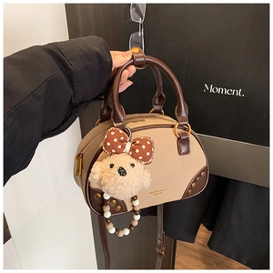 Détail du sac Boston avec clous rétro et pendentif ours en peluche à nœud à pois