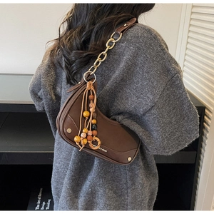 Detail of dark brown crescent chain bag with colorful beads on a shoulder-back pose