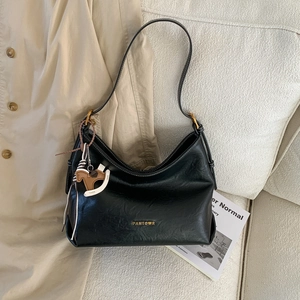 Detail of black lychee leather shoulder bag with gold logo and horse charm