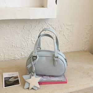 Detailed macro view of light blue Boston bag with star pendant and silver hardware zippers