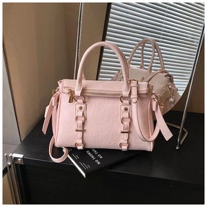 Close-up of pink tote bag showing pleated texture and gold ring metal buckles