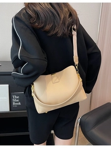 Sac seau chic en cuir beige avec large bandoulière vue de dos pour un style moderne