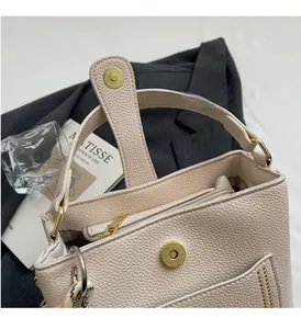 Détail du sac seau en cuir grainé beige avec fermoir magnétique doré et zip intérieur