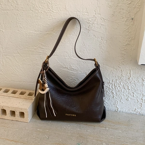Close-up of brown PU leather tote with brand logo and vintage gold metal buckle detail