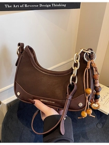 Sac demi-lune marron foncé avec chaîne dorée et breloques en perles de bois