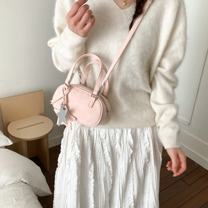 Detail of light pink mini Boston bag with silver star pendant and adjustable strap