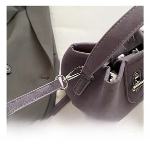 Detailed view of silver metal hooks and purple lychee grain leather on the bucket bag