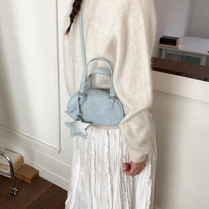 Detail of light blue crossbody bag with silver star pendant on smooth PU leather
